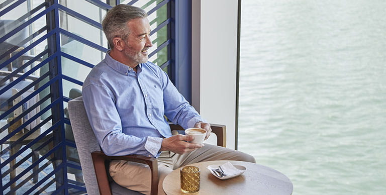 A man enjoying coffee whilsy cruising solo on Spirit of the Rhine